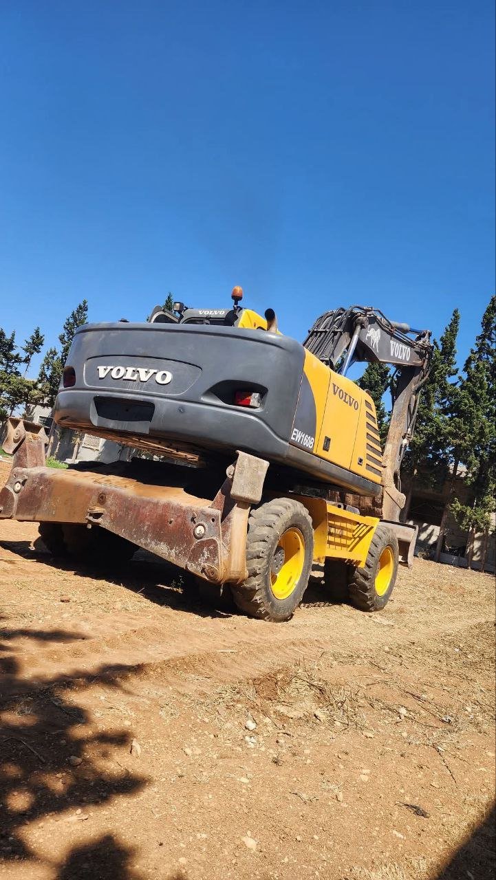 Excavator for sale in Syria, Volvo EW180E backhoe loader, 2007 model, located in Damascus, the best site for selling heavy equipment in Syria.